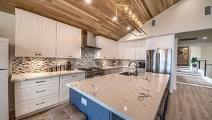 A modern kitchen with white cabinets, a large island, and a geometric light fixture. - CL 874 Million Dollar View. Lake is now 100% full! (Canyon Lake)