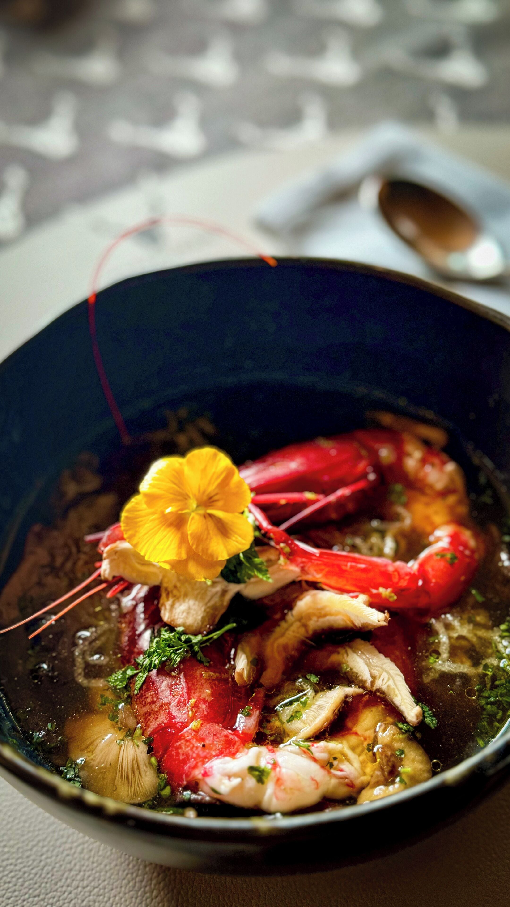 Eine Schüssel mit Fischsuppe und verschiedenen Zutaten.