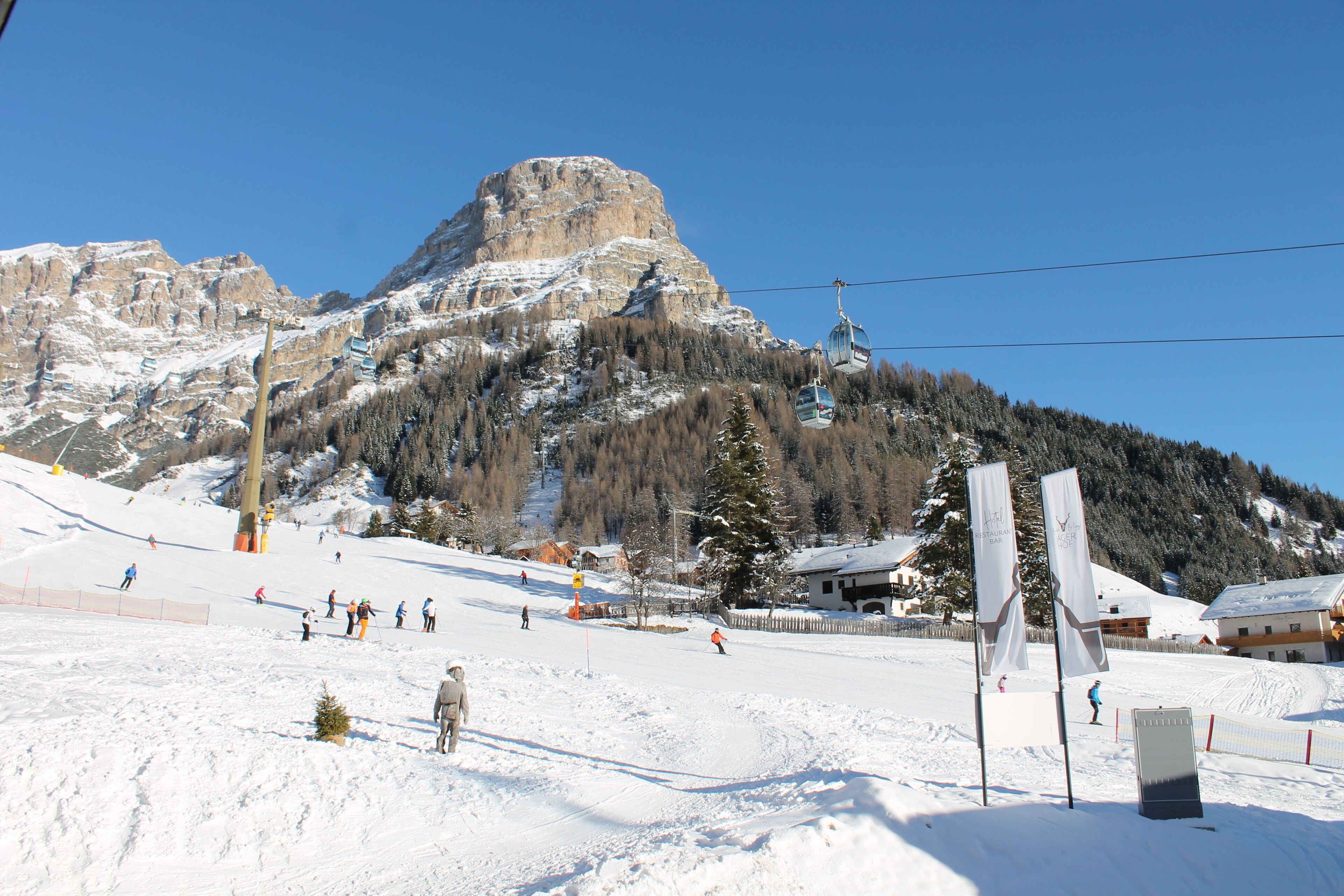 A ski resort with a mountain backdrop, ski lifts, and snow-covered slopes.