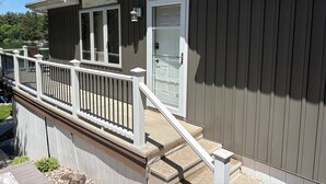 Une maison à deux étages avec un balcon, une cheminée et une porte.
