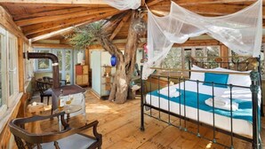 Une cabane en bois avec un lit, une table et une chaise.