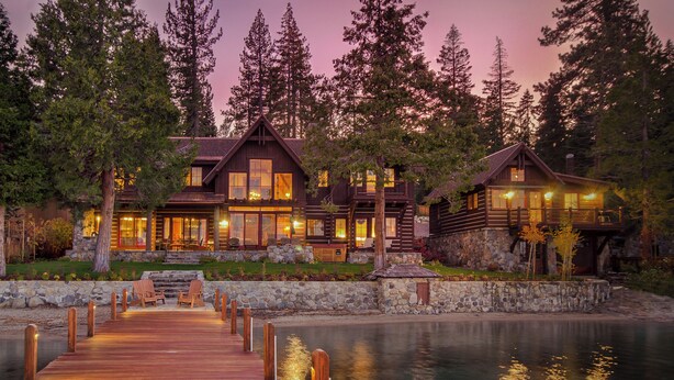 A lodge with a wooden deck leading to a dock, surrounded by trees and a body of water. - Peaceful Waters by Hauserman Rentals (Tahoma)