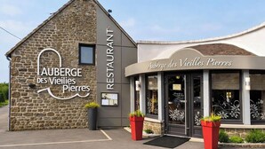 A restaurant named 'Auberge des Vieux Pierres' with a stone facade and a curved entrance.