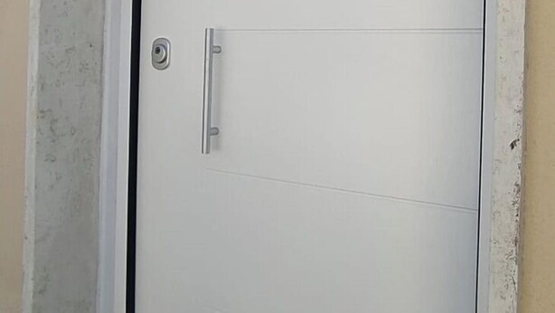 A white door with a handle, a peephole, and a small step leading up to it.