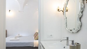 A modern bathroom with a large mirror, a sink, and a bedside table. - Banchi al Patio - Castel Sant Angelo (Rome)