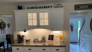 A kitchen with white cabinets, a granite countertop, and a sign reading "SUPER MARKET". - Saratoga Racetrack and SPAC getaway  (Saratoga Springs)