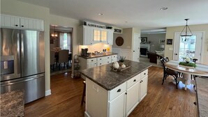 A spacious kitchen with white cabinetry, stainless steel appliances, and a central island. - Saratoga Racetrack and SPAC getaway  (Saratoga Springs)