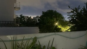 A rooftop garden with potted plants and a view of buildings in the background. - Hostel VIM (Cartagena)