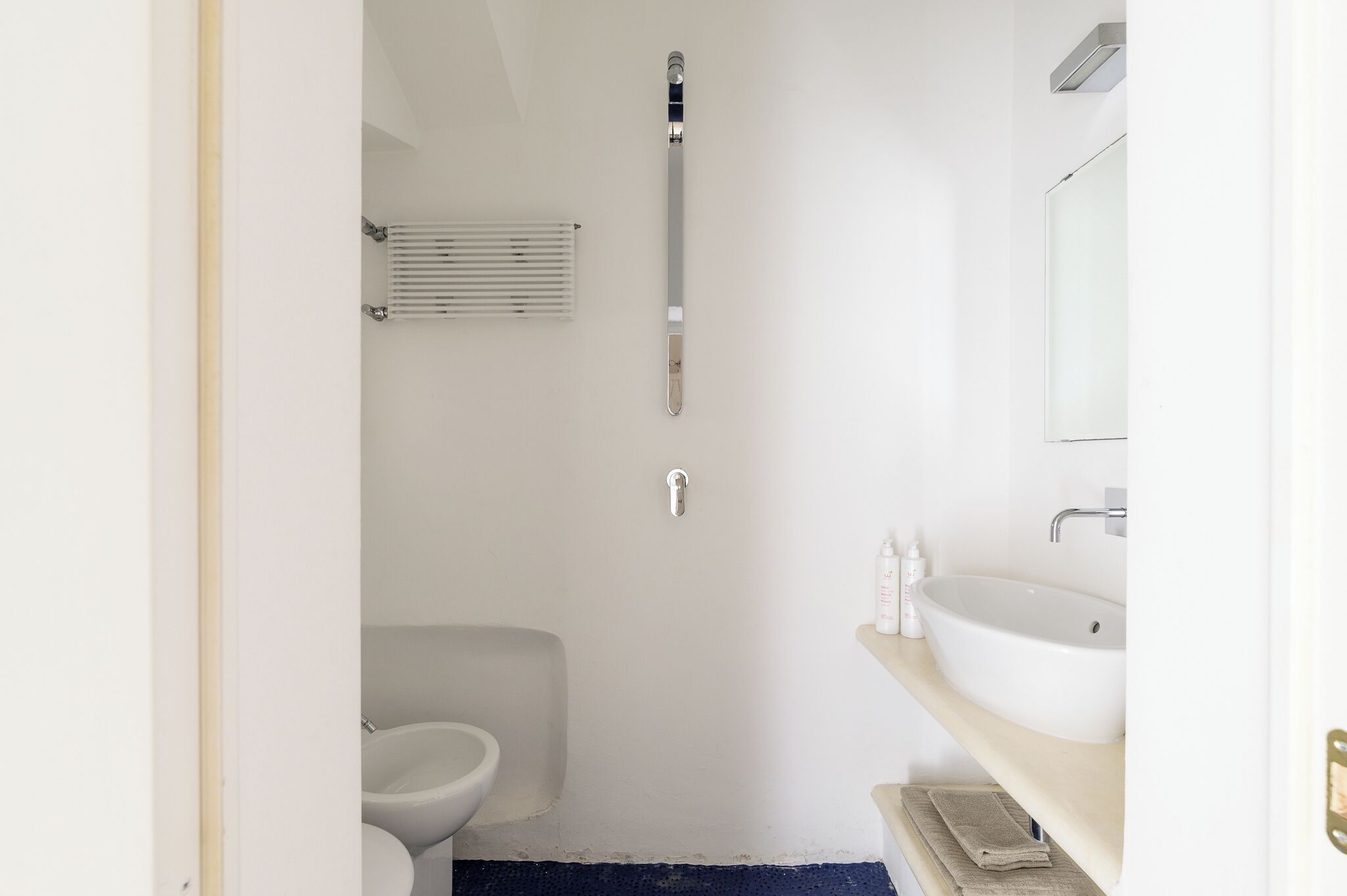 Un baño con inodoro, lavamanos, espejo y ducha.