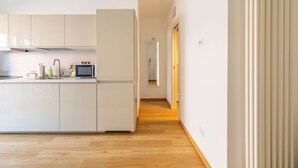 Una cocina moderna con armarios blancos, un microondas y un fregadero.