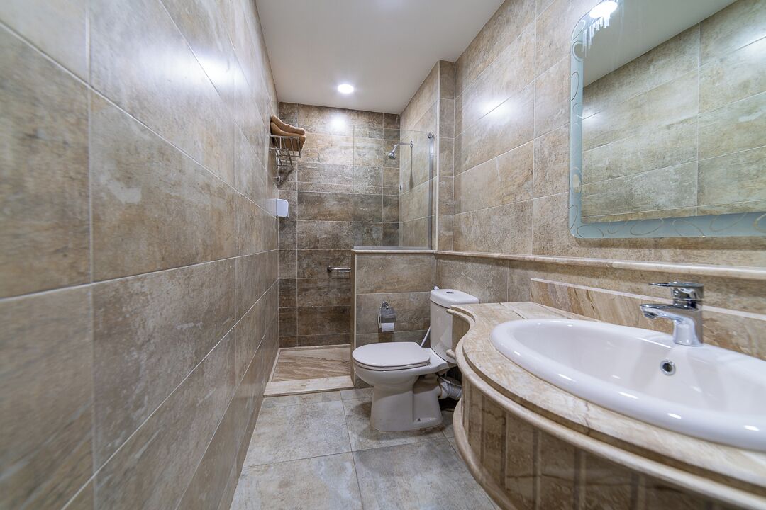 A bathroom with a shower, toilet, and sink.