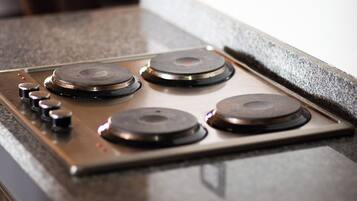 A kitchen with a stainless steel stove and a dark countertop.
