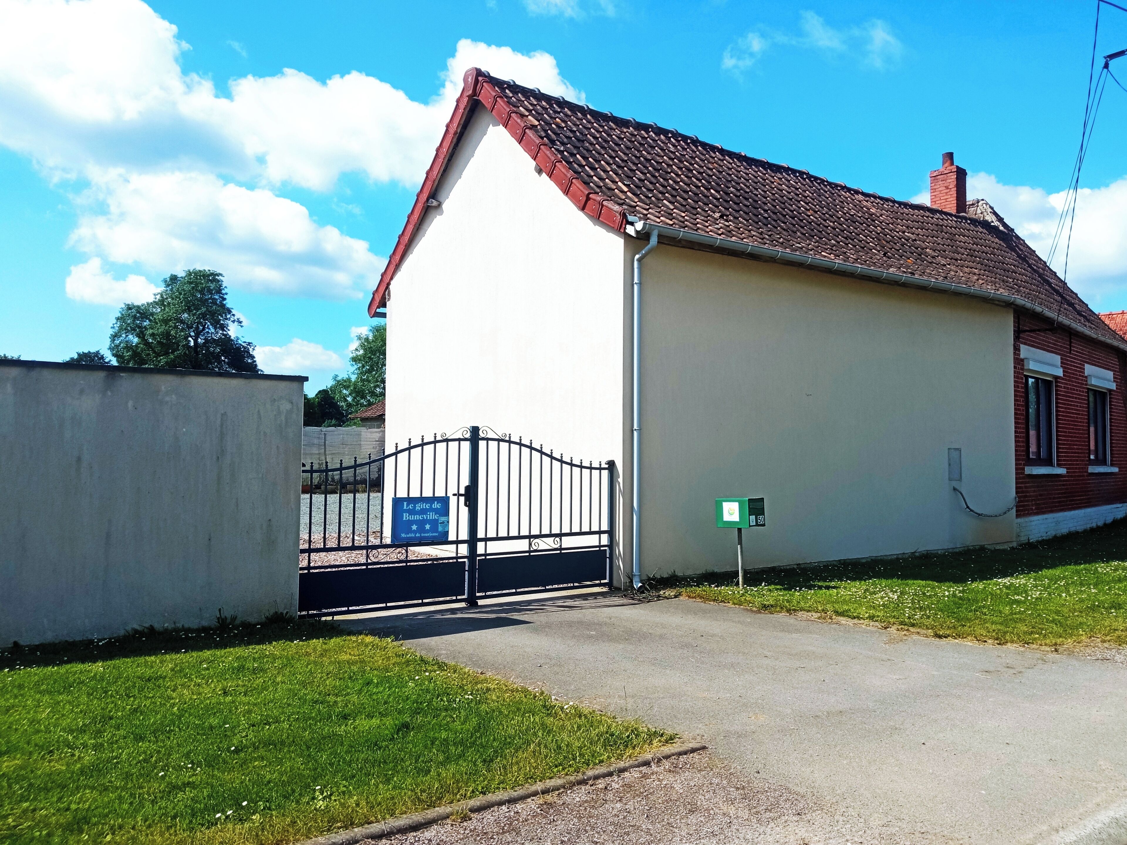 Un bâtiment d’un seul étage, doté d’un toit recouvert de tuiles rouges et de murs extérieurs blancs.
