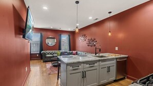 Une cuisine moderne avec des meubles gris, un plan de travail en marbre et un lave-vaisselle encastré.