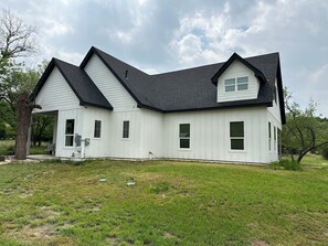 Ein zweistöckiges Haus mit Satteldach und einer Laube.