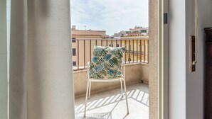 A balcony with a chair, a railing, and a view of buildings in the background. - Appartamento a due passi da Villa Trabia by Wonderful Italy (Palermo)
