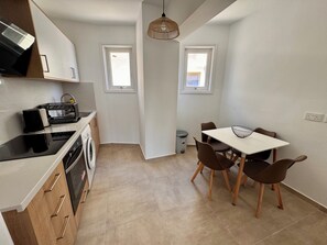 Kjøleskap, ovn, vannkoker og høy barnestol