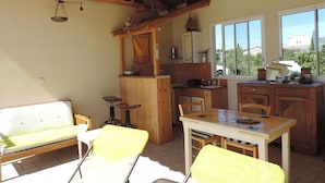 A rustic kitchen with wooden cabinets, a dining table, and a bench. - Bed and breakfast, private parking, SWIMMING POOL (Cavaillon)
