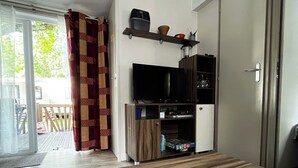 Una sala de estar moderna con una mesa de comedor de madera, un televisor de pantalla plana y un mueble empotrado para entretenimiento.