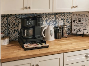 A kitchen counter with a coffee maker, a kettle, and a coffee filter box. - Island Vibes Beach House~ 4 min. Walk 2 Beach • Heated Pool • King Beds (Melbourne Beach)