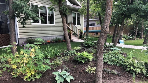 Il s’agit d’une propriété résidentielle dotée d’un jardin bien entretenu, d’une terrasse en bois et d’une maison avec un porche à l’avant.