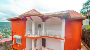 A two-story building with a balcony, a satellite dish, and a water tank. - Mountains View Villa  (Freetown)