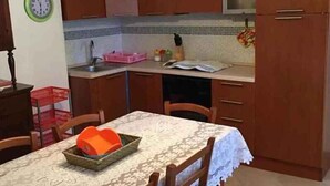 Una cocina con armarios de madera, un fregadero y una mesa de comedor con sillas.