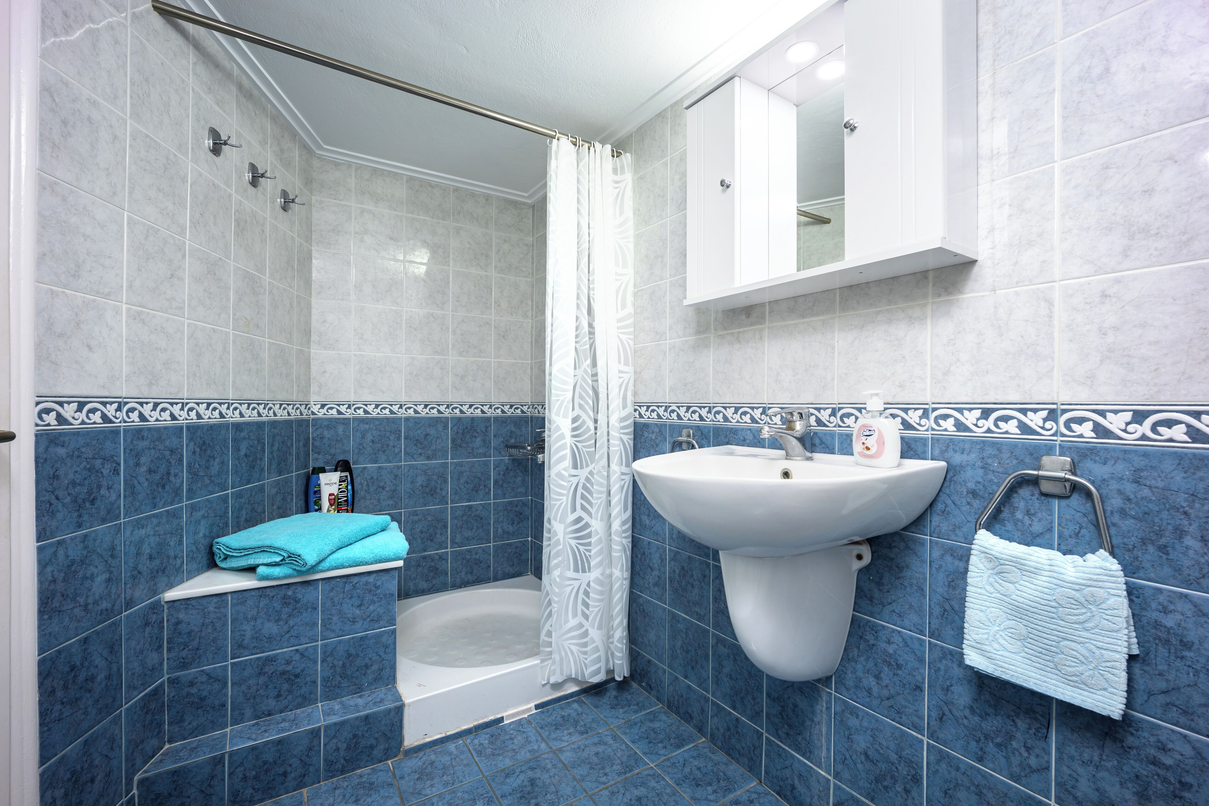 A bathroom with a bathtub, a sink, and a shower curtain.