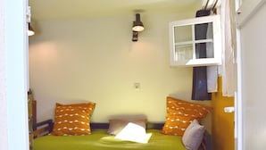 Une petite pièce agréable, avec un lit, une table et une fenêtre.