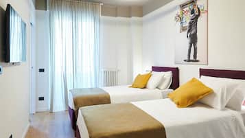A hotel room with two beds, a large window with curtains, a radiator, and a painting on the wall.