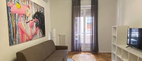 Deluxe appartement | Woonruimte | Een 43-inch flatscreentelevisie met satellietzenders