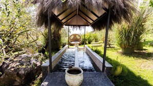 A garden pathway leading to a thatched-roof structure with a seating area. - La Casetta dello Scoiattolo  (Gavorrano)