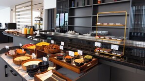 Un espace buffet proposant divers plats et une station de préparation de café.
