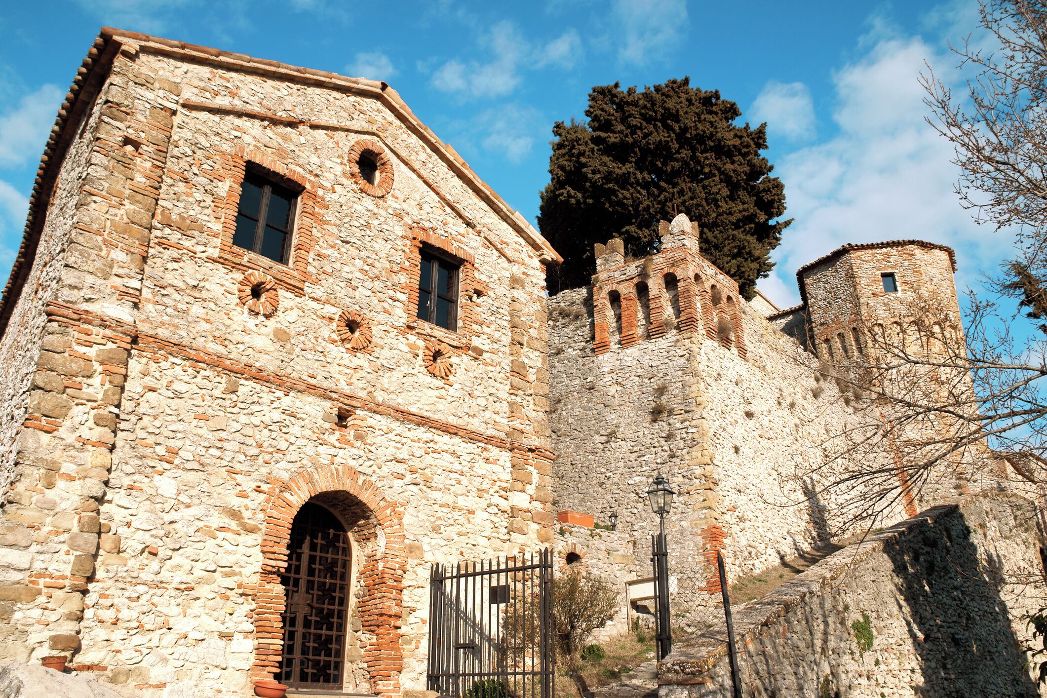 Ein historisches Steinhaus mit Rundbogenfenstern und einem Tor.