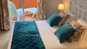 A bedroom with a bed, pillows, a lamp, and a view of an outdoor area with chairs and a railing. - Apartamento CON Gran Terraza Y Acceso Directo A Piscina (Dénia)