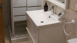 A bathroom with a shower enclosure, a sink, a mirror, and a toilet. - Apartamento CON Gran Terraza Y Acceso Directo A Piscina (Dénia)