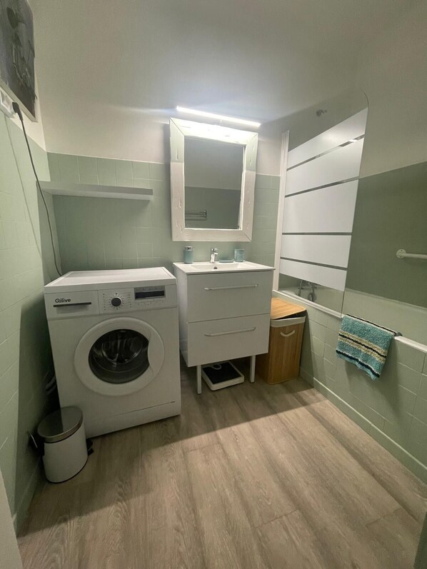 A compact laundry room with a washing machine, a sink, and a mirror. - Mise au Vert F2 à 5 mns des Commerces et 2 mns des Thermes Mer et la Montage (Amélie-les-Bains-Palalda)