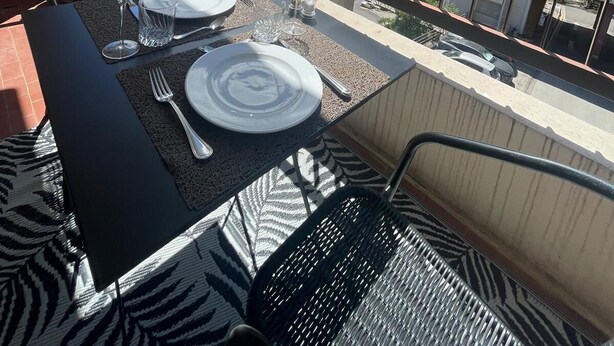A balcony with a table set for dining, overlooking a mountainous landscape. - Mise au Vert F2 à 5 mns des Commerces et 2 mns des Thermes Mer et la Montage (Amélie-les-Bains-Palalda)