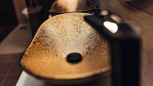 A close-up of a textured, metallic object with a central hole, possibly a part of a piece of furniture or equipment. - Deluxe Double Room (Faro)