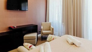 A hotel room with a bed, a desk, a chair, and a TV. - Deluxe Double Room (Faro)