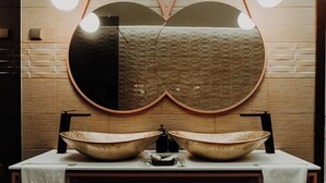 A bathroom with a double sink, a large mirror, and a towel rack. - Deluxe Double Room (Faro)