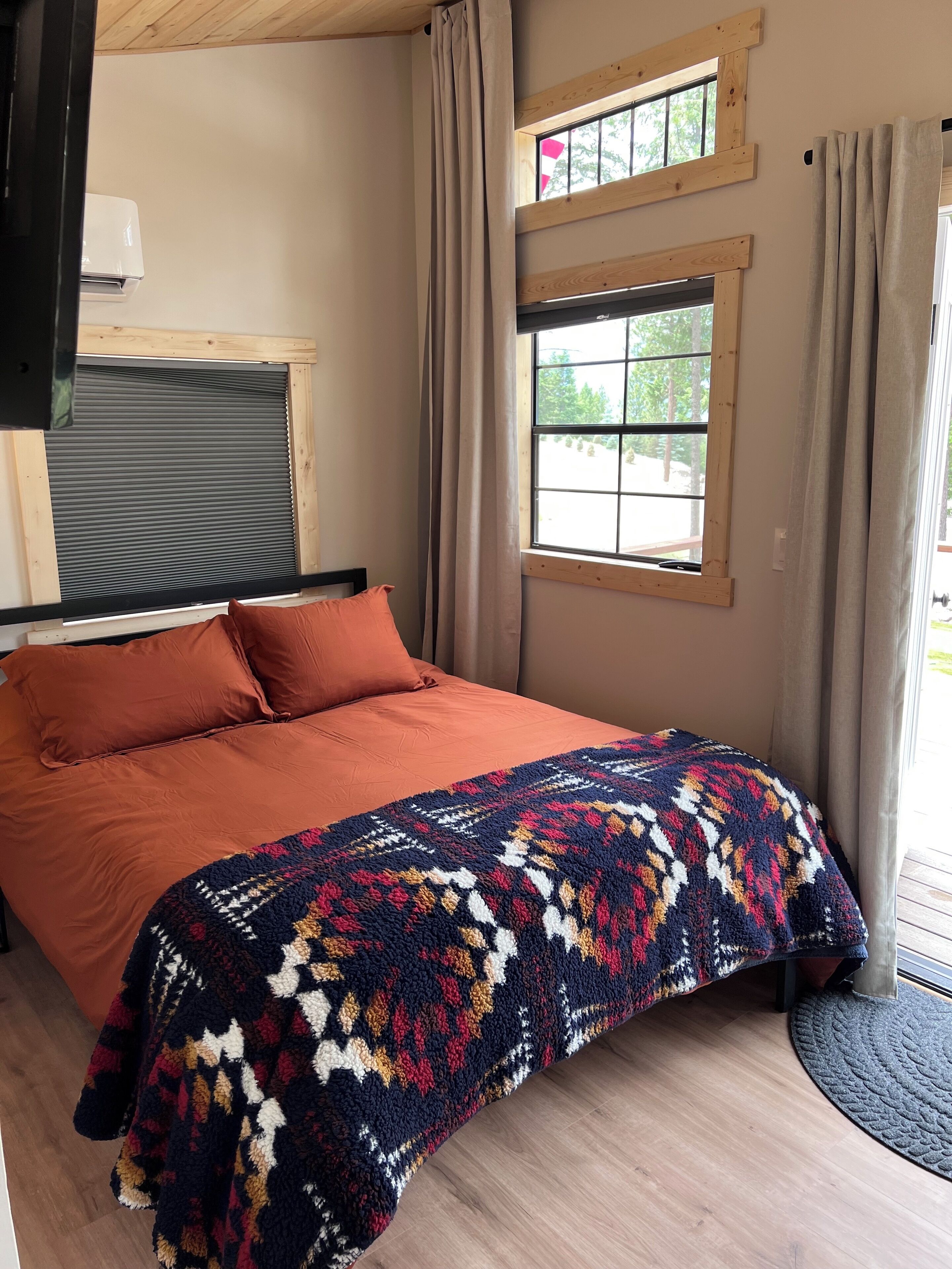 Une chambre à coucher avec un lit, une fenêtre et des rideaux.