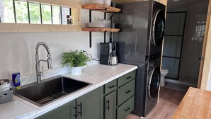 A modern kitchen with a sink, coffee maker, and a built-in washer.