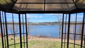 Un espacio de estar al aire libre cubierto con vistas a un lago y al paisaje circundante.