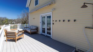 A deck with outdoor furniture, a sliding glass door, and a white railing. - Plum Cove Beach Paradise. Overlook Plum Cove from your kitchen n only steps away (Gloucester)