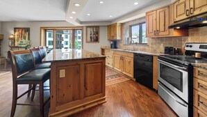 Une cuisine moderne avec des meubles en bois, un îlot central et une grande cuisinière.