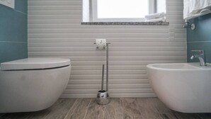Ein Badezimmer mit Toilette, Bidet und Fenster.