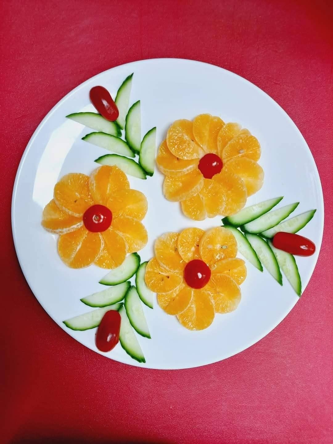 A plate with fruit arrangements on a red background.