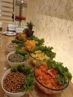 A buffet table with various food items and a beverage dispenser.