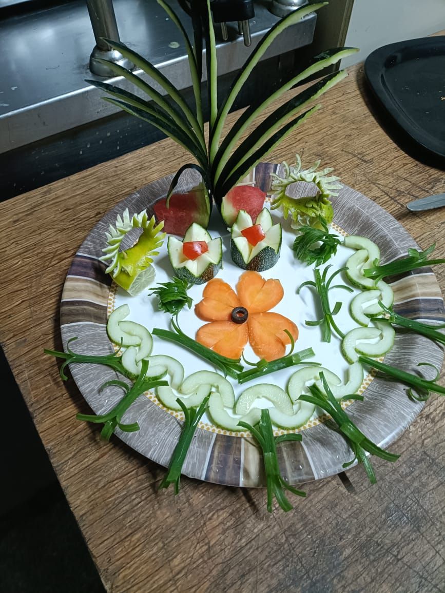 Un plato decorativo con diversos vegetales dispuestos en un diseño floral.